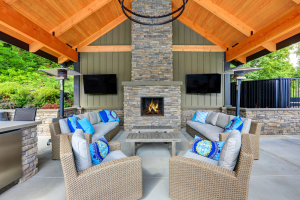 Wood ceiling patio with stacked stone fireplace and stone accent surround walls