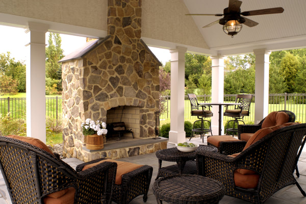 Outdoor stone masonry fireplace in covered patio