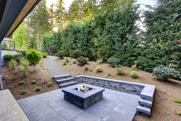 Picturesque new patio with large stone grey pavers and fire pit