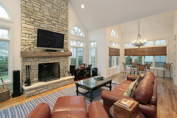 Living room with vaulted ceiling and stone masonry fireplace hearth